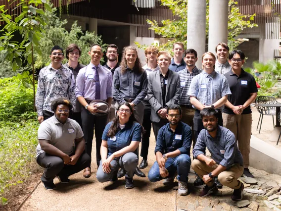 Group of 16 UA undergrads standing together posed for the picture