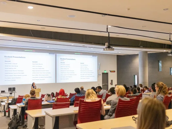 Lecture hall full of people watching presentations