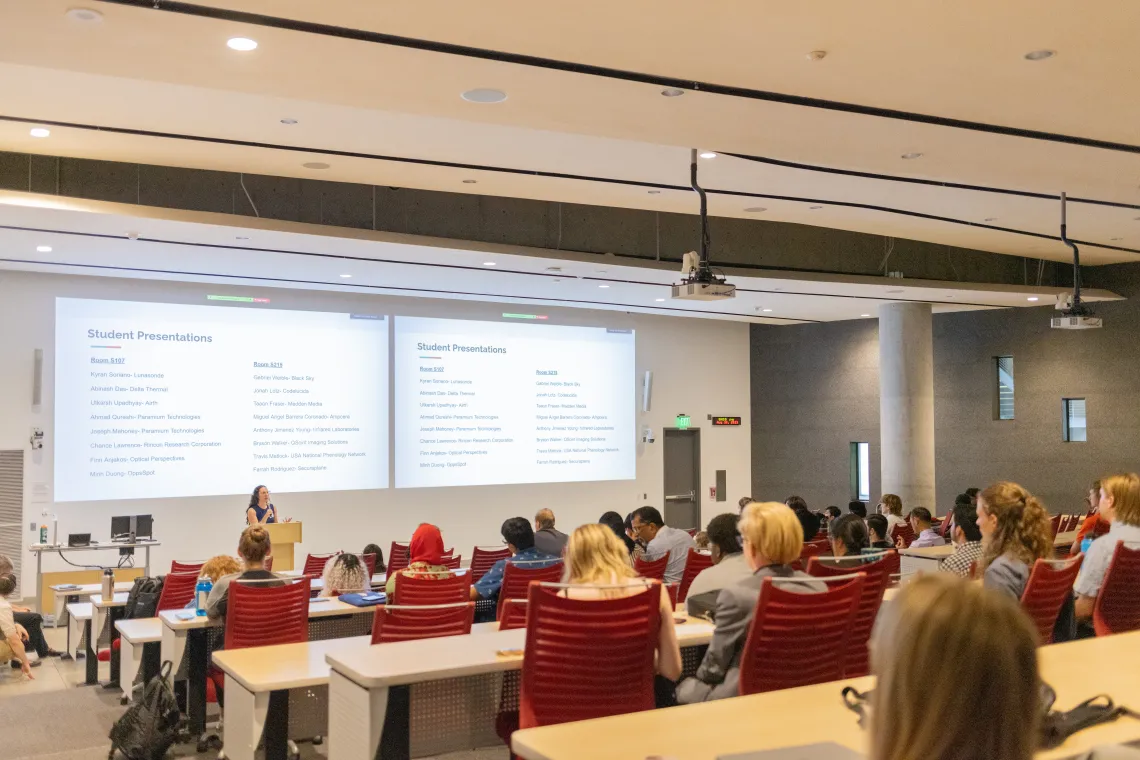 Lecture hall full of people watching presentations